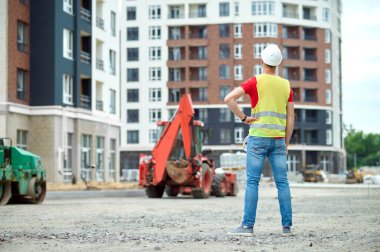 Deneyimli erkek işçi yeni bir inşaat nesnesini inceliyor.