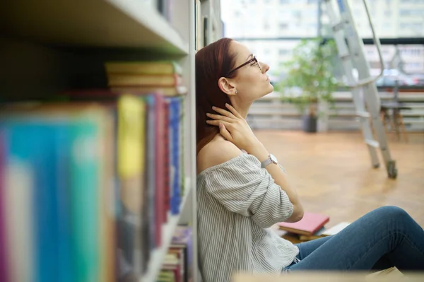 図書館の床に座った過労研究者 — ストック写真