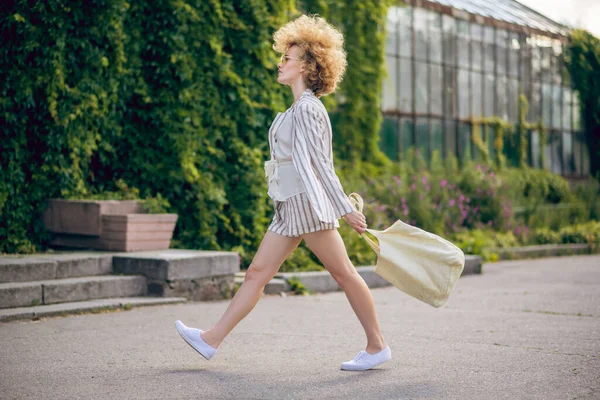 Chica pelirroja en pantalones cortos cruzando la calle —  Fotos de Stock