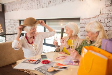 Yeni bir şapka denerken heyecanlı görünen kadınlar