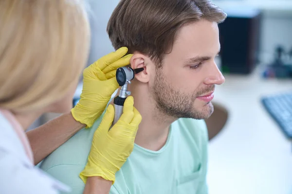 Lugn söt man genomgår en otoskopi förfarande på en klinik — Stockfoto