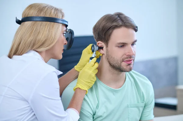 Doctor performing an otoscopic examination of the patients auditory canal — Stock Photo, Image