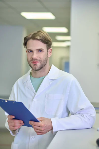 Selbstbewusster Mann im Arztkittel mit Ordner — Stockfoto