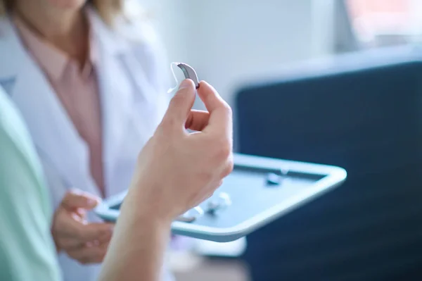 Hand hält Hörgerät in die Höhe — Stockfoto