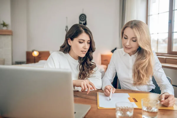 Dos mujeres sentadas a la mesa y discutiendo un acuerdo —  Fotos de Stock