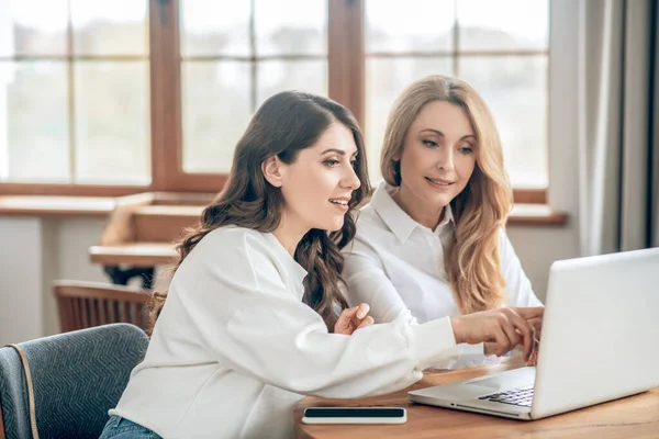 Due colleghe che discutono un accordo e sembrano coinvolte — Foto Stock