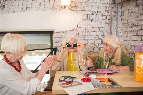 Tři ženy se dobře baví při zkoušení nových slunečních brýlí — Stock fotografie
