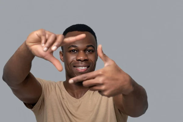 Mladý muž tmavé pleti dělá gesta rukama — Stock fotografie