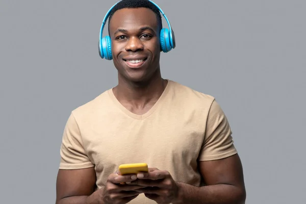 Joven de piel oscura con auriculares escuchando música — Foto de Stock