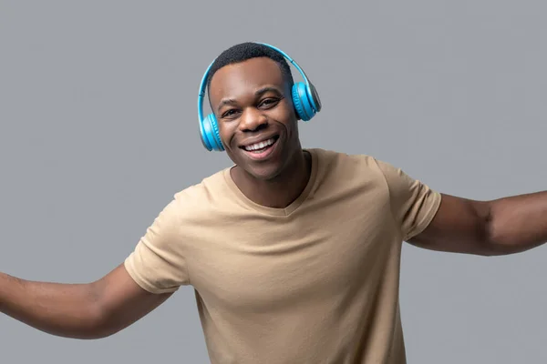 Joven de piel oscura con auriculares escuchando música — Foto de Stock