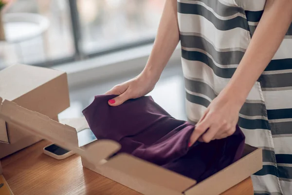Erfahrene Verkäuferin bereitet Kleidungsstück für den Versand vor — Stockfoto