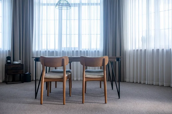 Table with chairs in center of room — Stock Photo, Image