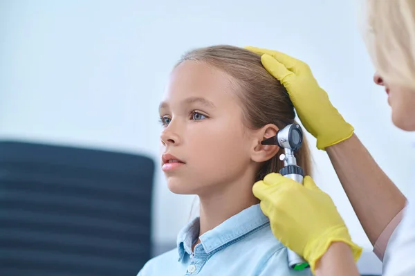 Ernstig meisje van school leeftijd onderzocht door otolaryngoloog — Stockfoto