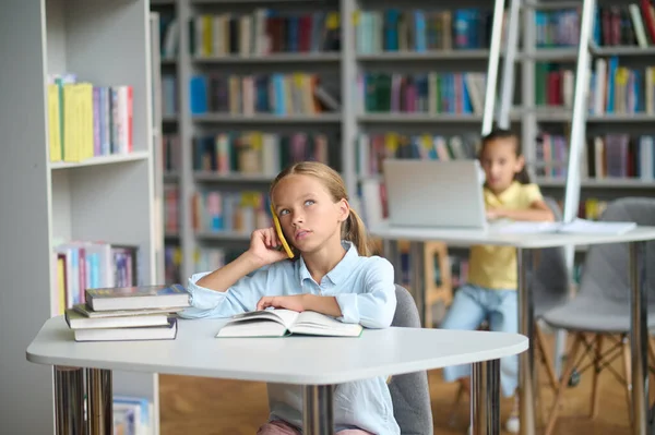 Aluno bonito fazendo um telefonema de uma biblioteca — Fotografia de Stock