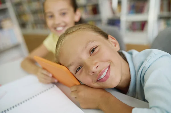 Två glada klasskamrater på ett bibliotek — Stockfoto