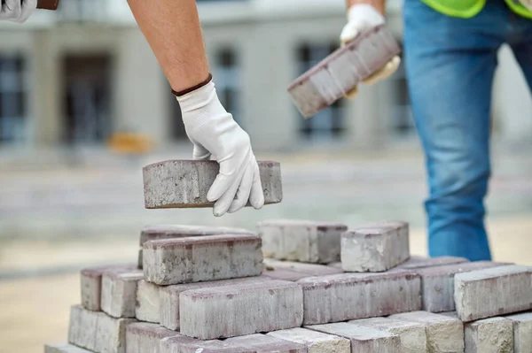 Caucasian male workers holding building materials with gloved hands — Stock Photo, Image