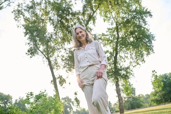 Щаслива жінка проводить дозвілля в зеленому парку — стокове фото