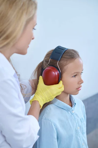 Chica siendo preparada para una prueba de audición por un profesional médico —  Fotos de Stock