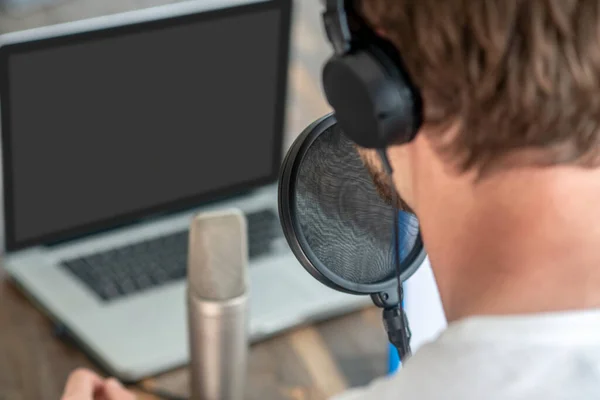 Una foto de un hombre con auriculares negros hablando en micrófono —  Fotos de Stock