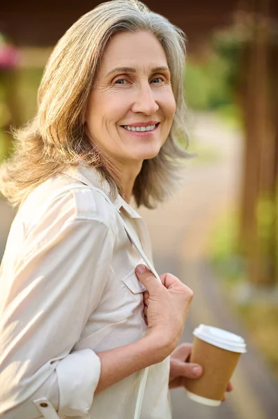 Mujer optimista adulta con café al aire libre — Foto de Stock