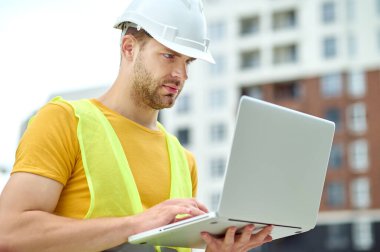 Bilgisayarı üzerinde çalışan konsantre erkek mühendis.