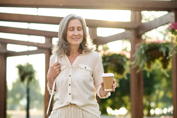 Volwassen vrouw genieten van wandeling in het park — Stockfoto