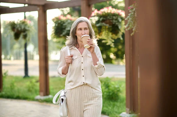 ハンドバッグ公園でコーヒーを飲む女性 — ストック写真