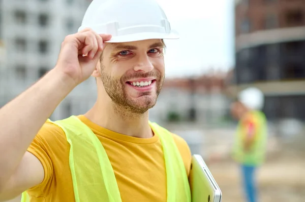 Trabajador barbudo de alto espíritu en ropa de cabeza protectora posando para la cámara —  Fotos de Stock