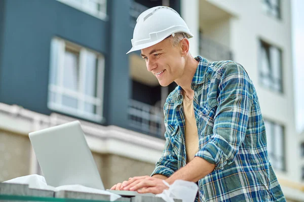 Ingeniero de construcción enfocado usando su gadget en el sitio de construcción — Foto de Stock