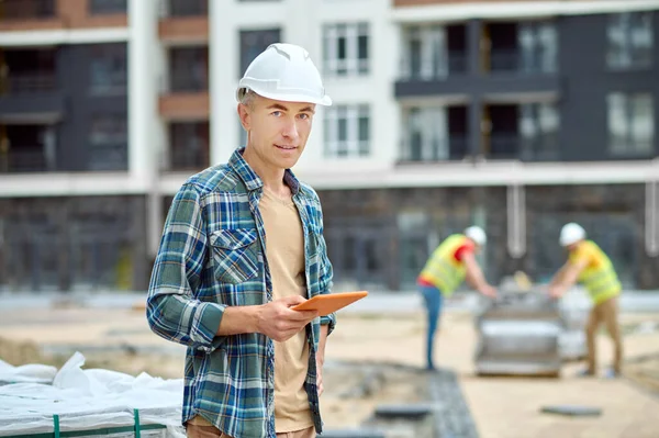 Ingeniero tranquilo posando para la cámara en el sitio de construcción —  Fotos de Stock