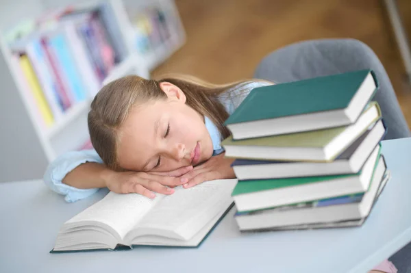 Trött elev slumrar på en öppen lärobok — Stockfoto
