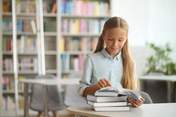 Memnun liseli kız kitap okumaya odaklanmış. — Stok fotoğraf