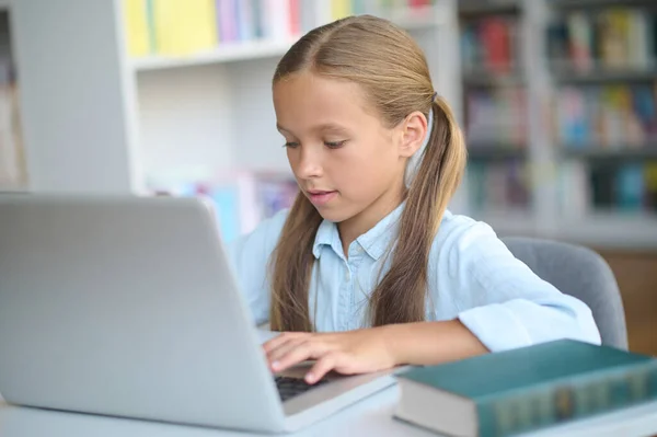 Enfocado chica joven usando un gadget en el aprendizaje — Foto de Stock