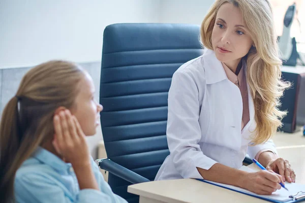 Dame médecin expérimenté recevant une patiente dans son bureau — Photo