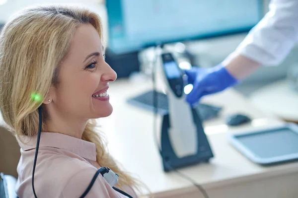 Zufriedene Patientin lächelt während des Audiometrie-Tests — Stockfoto