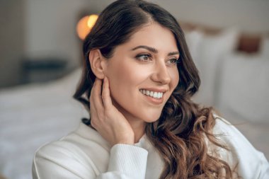 Beyaz bluzlu, uzun saçlı güzel bir kadın.