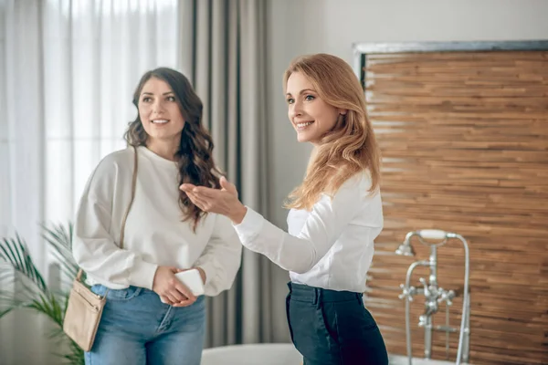 Mujer joven hablando con un agente de bienes raíces sobre alquilar un apartamento — Foto de Stock