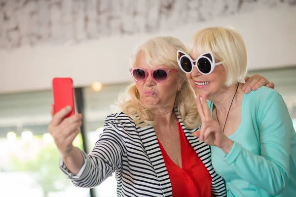 Dvě starší vzrušené ženy dělat selfie a baví — Stock fotografie