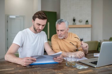 İki adam bir projede birlikte çalışıyor ve ilgileniyorlar.