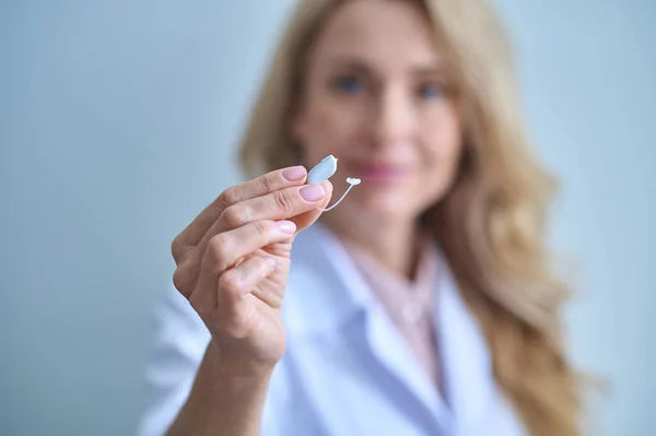 Hearing aid with graceful hand of woman medic