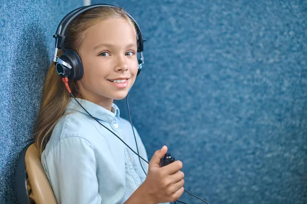 Dziewczyna w specjalnych słuchawkach sprawdza słuch — Zdjęcie stockowe