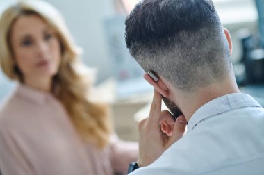 Doktor işitme cihazı ve kadın hasta.