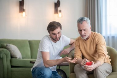 Genç adam babasına yeni akıllı telefonu nasıl kullanacağını öğretiyor.