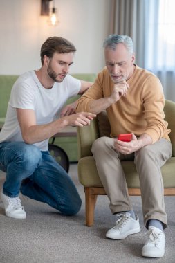 Genç adam babasına yeni akıllı telefonu nasıl kullanacağını öğretiyor.
