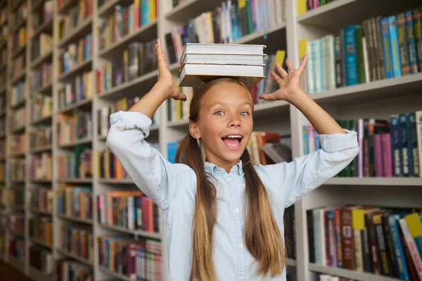 Funny girl with ponytails posing for the camera at the library — Stock Photo, Image