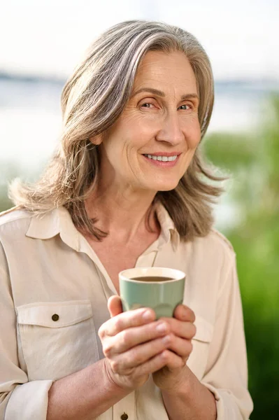 자연계에 컵을 들고 기뻐하는 성인 여자 — 스톡 사진