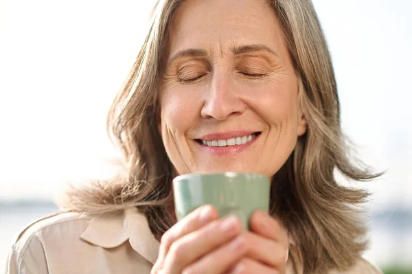 Mulher com olhos fechados segurando café — Fotografia de Stock