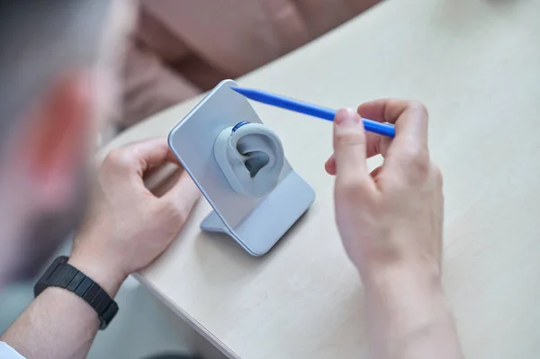 Médecin montrant l'aide auditive au patient — Photo