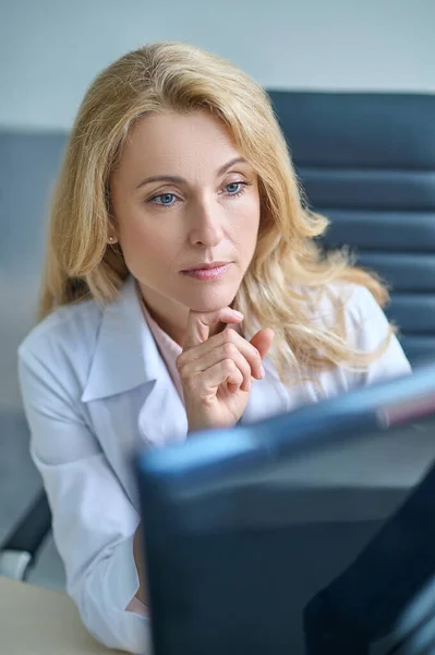 Doświadczony lekarz przyglądający się uważnie monitorowi komputerowemu — Zdjęcie stockowe