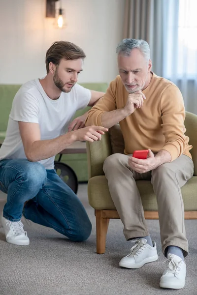 Genç adam babasına yeni akıllı telefonu nasıl kullanacağını öğretiyor.